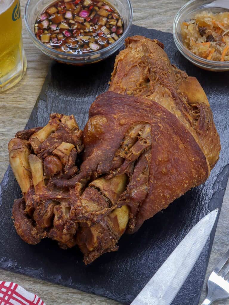 crispy pata on a cutting board.