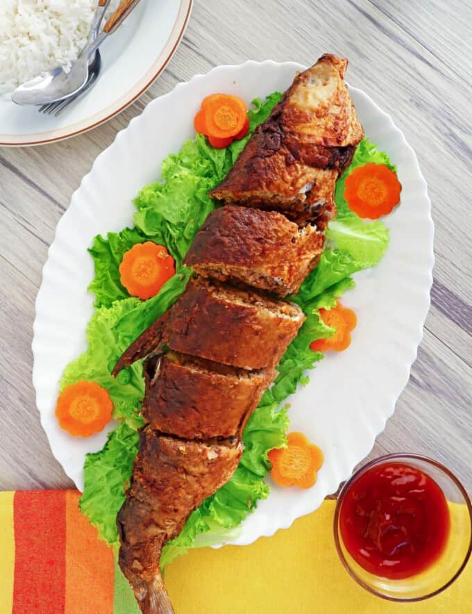 Relyenong Bangus on a white serving platter with carrot and lettuce garnish.