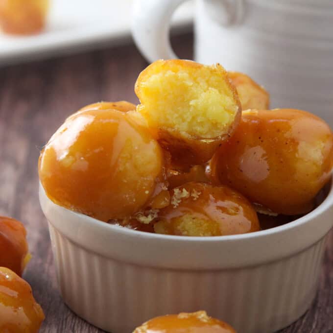 yema candies coated with caramel in a white bowl.