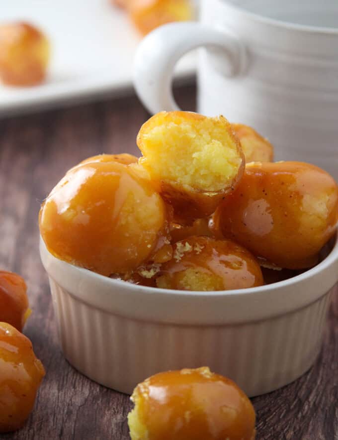 yema candies coated with caramel in a white bowl.