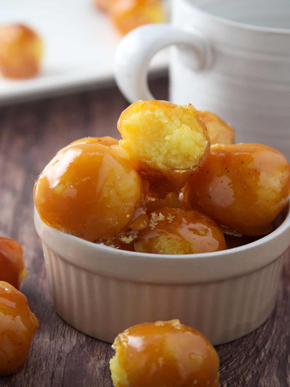 yema candies coated with caramel in a white bowl.