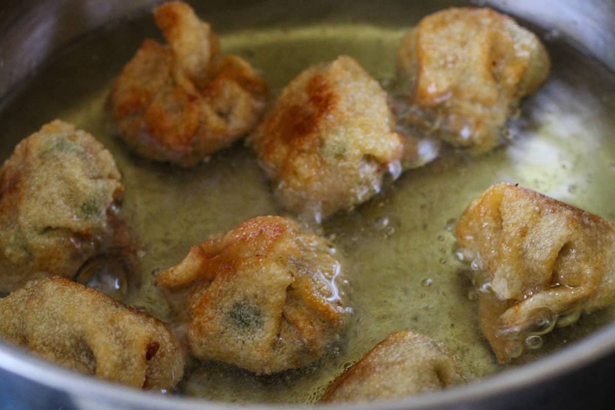 frying longganisa wontons in a pan.