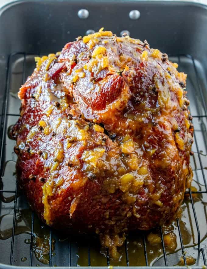 bone-in ham brushed with pineapple glaze on a roasting rack