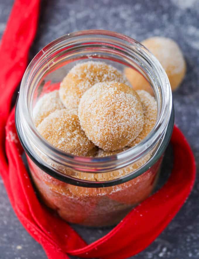 dulce de leche pastillas in a mason jar with red ribbon in the background.