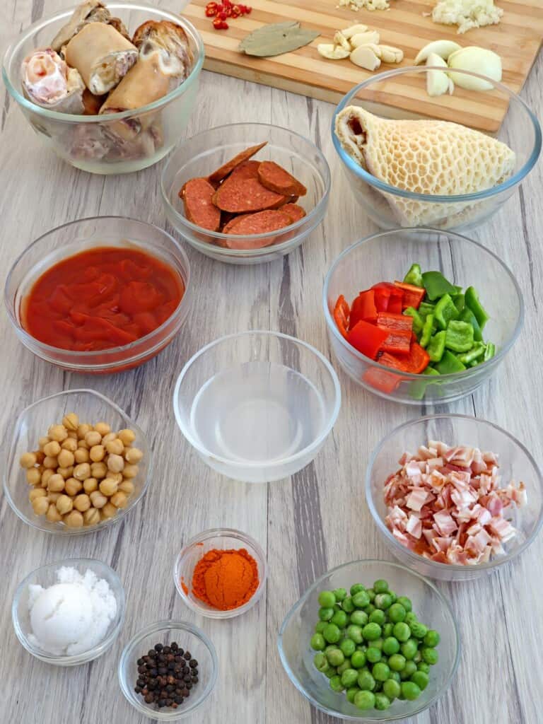 beef tripe, ox feet, chopped bacon, bell peppers, garbanzo beans, paprika, green peas, Chorizo de Bilbao in individual bowls