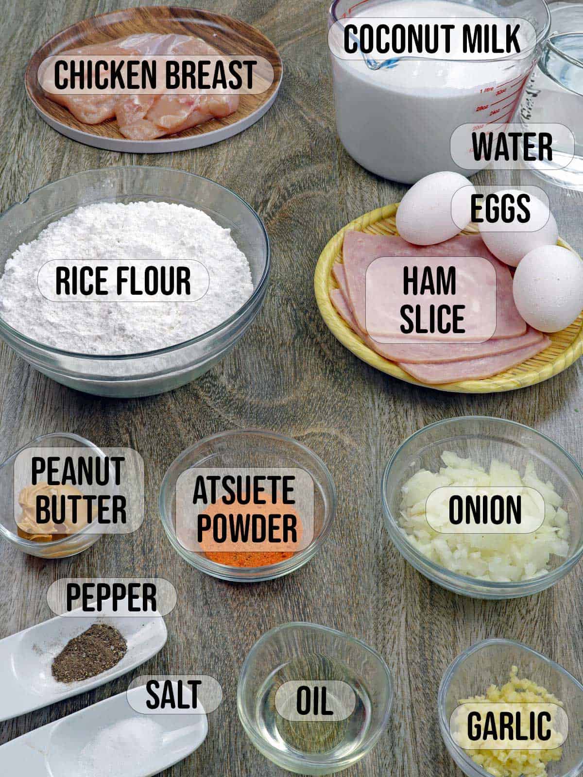 eggs, ham, rice flour, peanut butter, atsuete powder, oil, garlic, onions, salt, pepper, chicken, coconut milk in bowls.