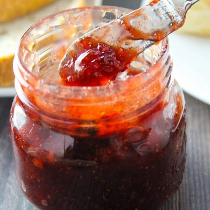 Serving Black Pepper Strawberry Jam from mason jar with a spoon