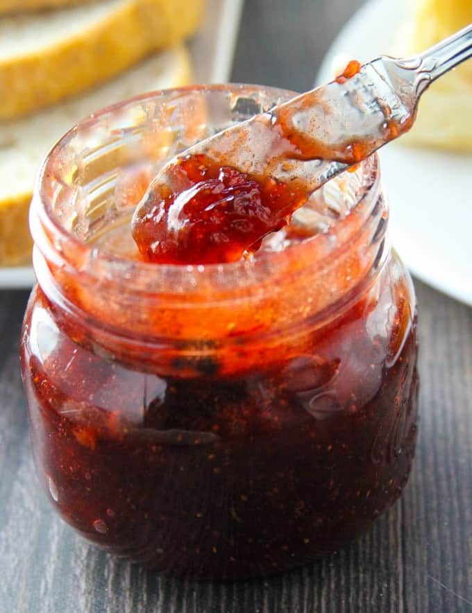 Serving Black Pepper Strawberry Jam from mason jar with a spoon