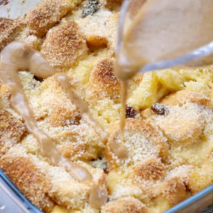 pouring caramel sauce over baked bread pudding.