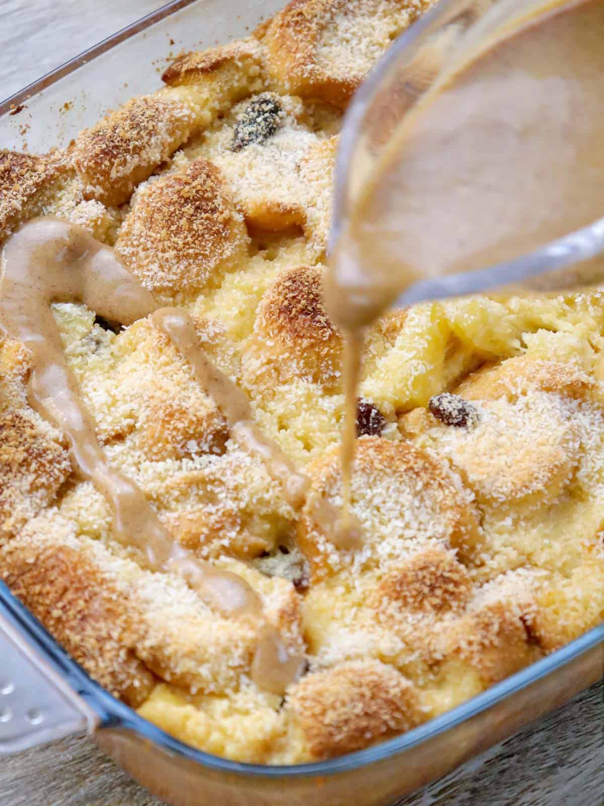 pouring caramel sauce over baked bread pudding.