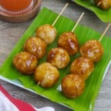 fried sticky rice balls with brown sugar glaze in bamboo skewers.