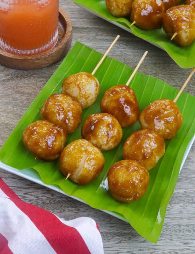 fried sticky rice balls with brown sugar glaze in bamboo skewers.