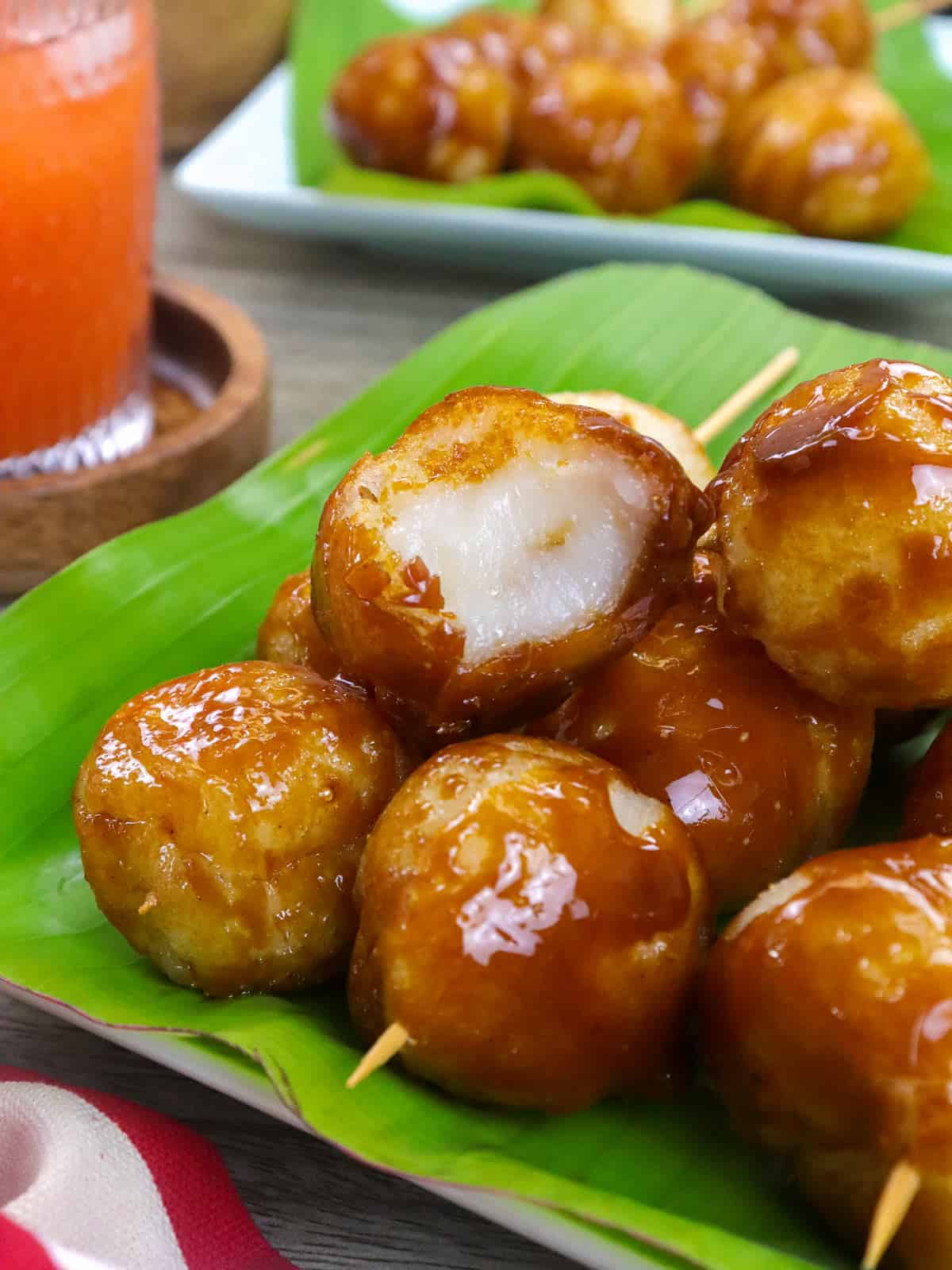 tungi-tungi rice balls in bamboo sticks on a banana-lined plate.