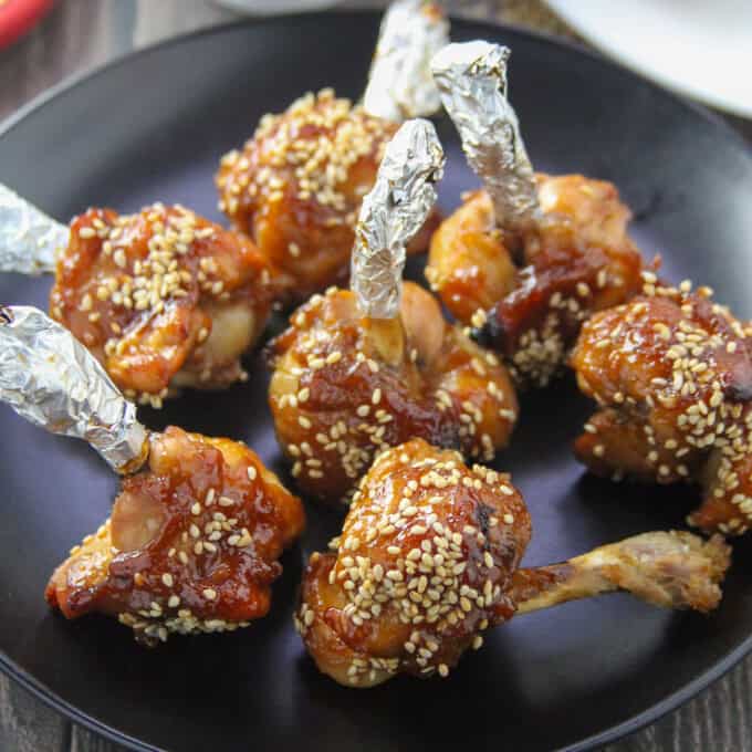 Plum Sauce Chicken Lollipops on a black plate.