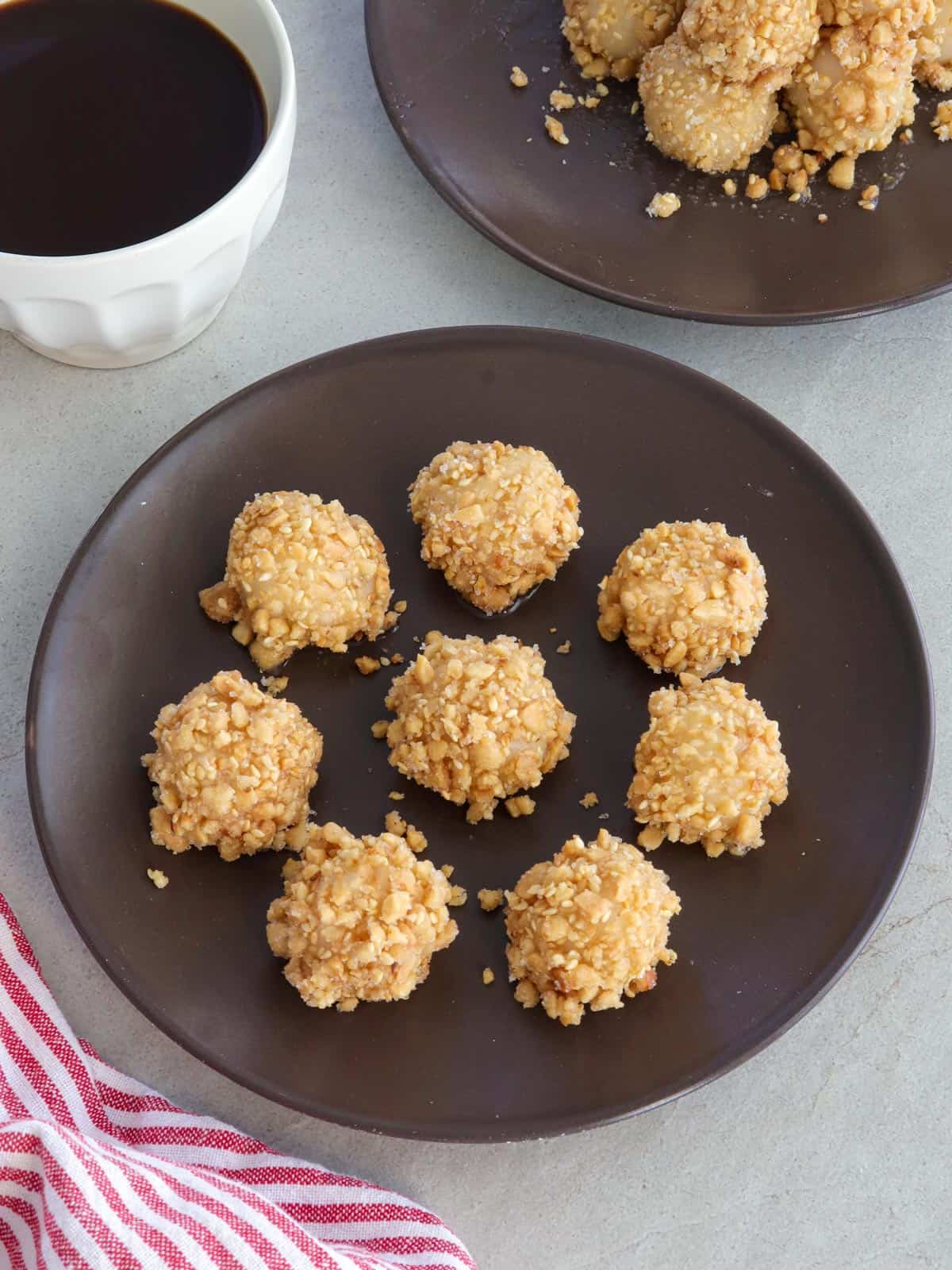 Sticky Rice Balls coated with peanuts on a brown plate.