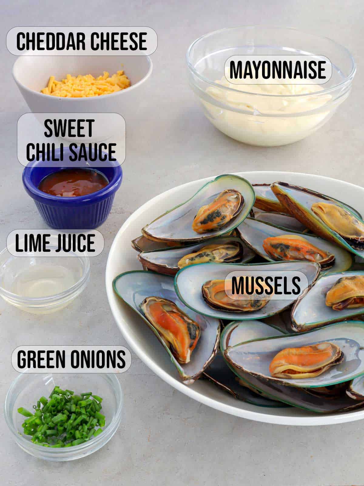 mussels, green onions, sweet chili sauce, mayonnaise, shredded cheese, lime juice in bowls.