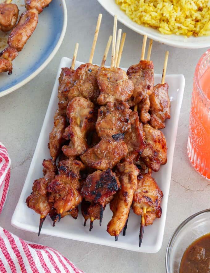 Filipino-style chicken bbq sticks on a white platter.