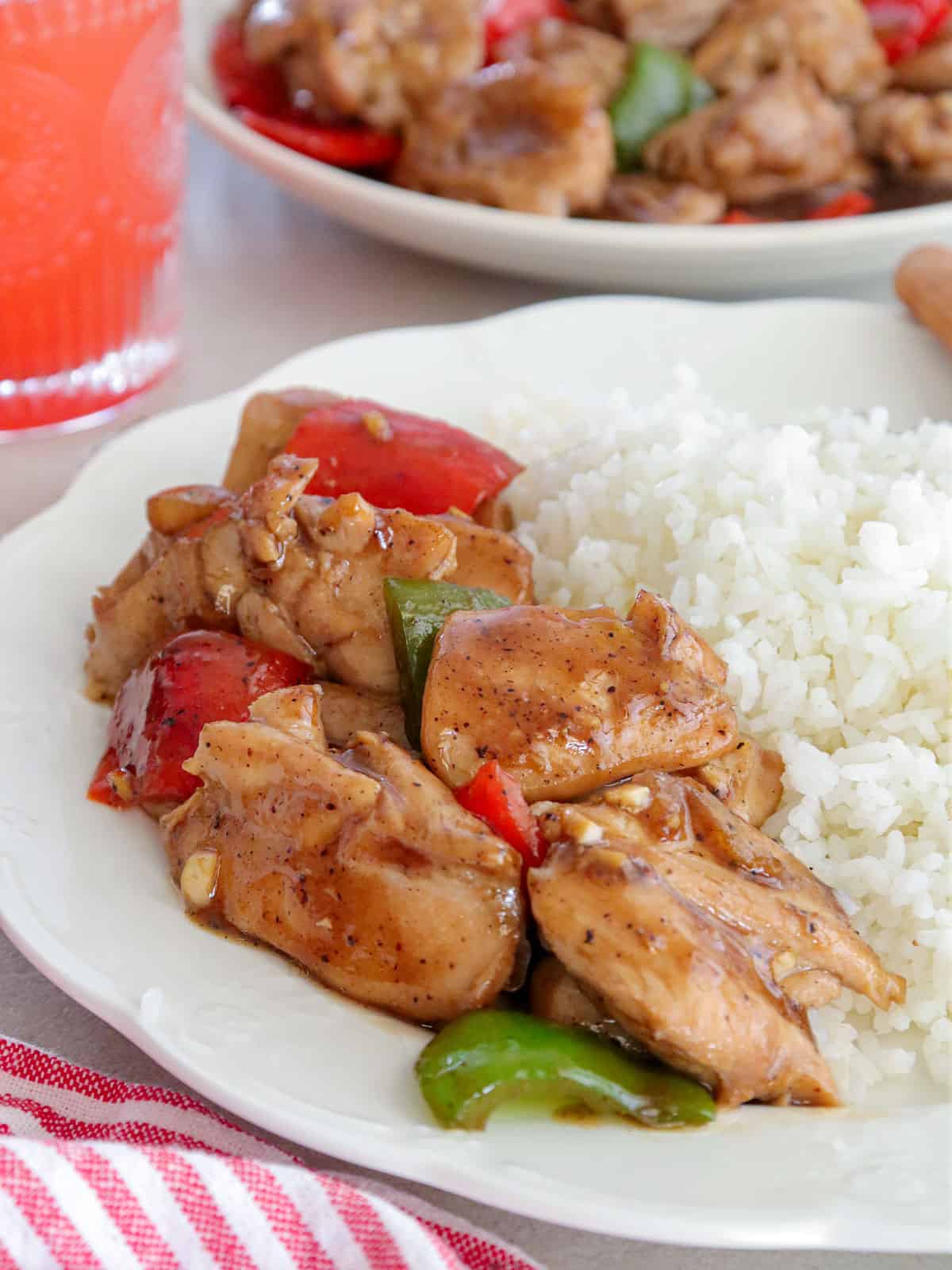 Black Pepper Chicken on a white plate with steamed rice.