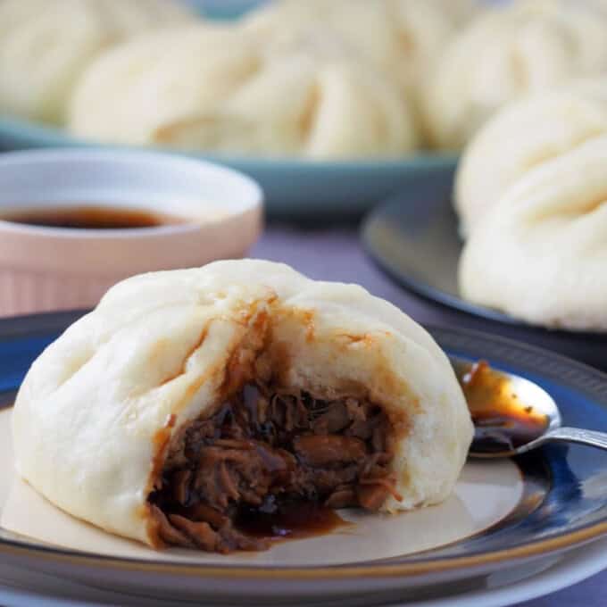 steamed pork buns on a plate.