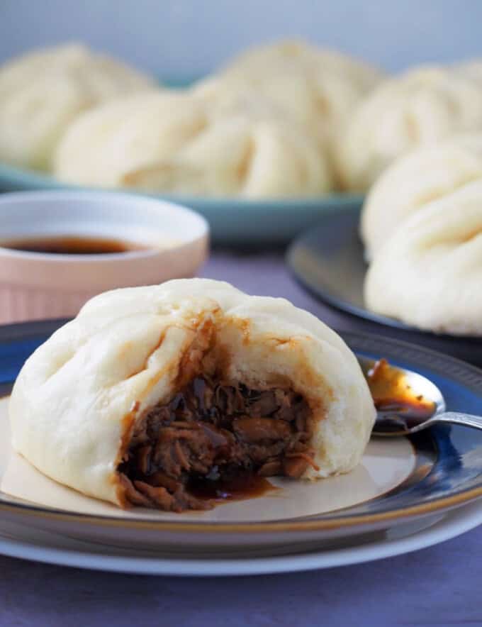 steamed pork buns on a plate.