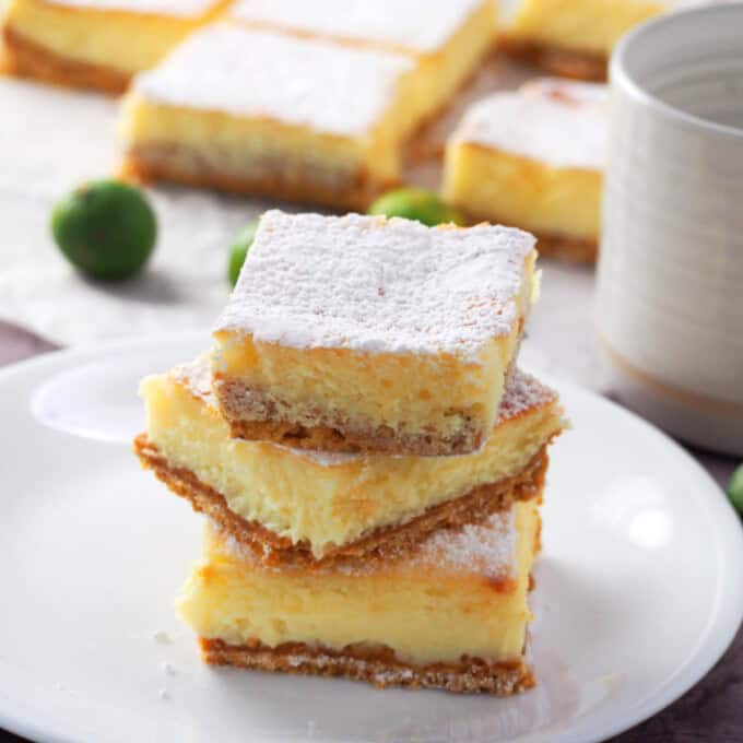 Calamansi Cheesecake Bars stacked on a white plate.