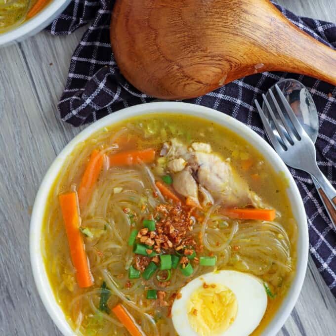 Chicken Sotanghon Soup in a white bowl with a half of hardboiled egg.