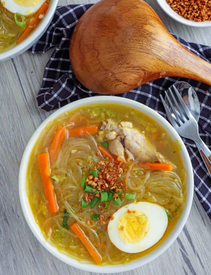 Chicken Sotanghon Soup in a white bowl with a half of hardboiled egg.