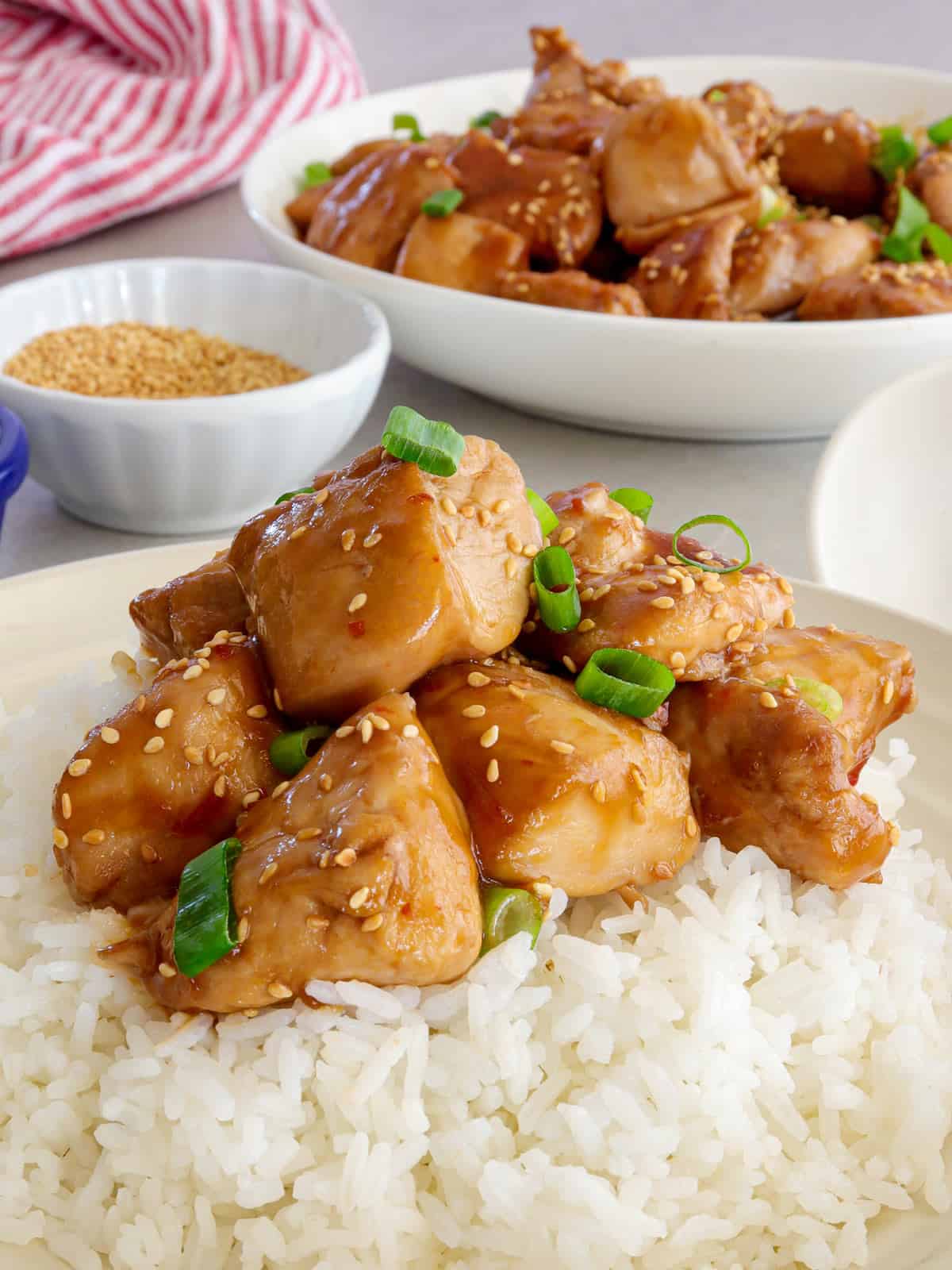 Sesame Chicken with steamed rice on a white plate.