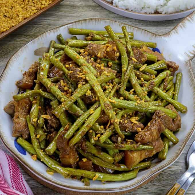 adobong sitaw with pork in a white serving bowl.