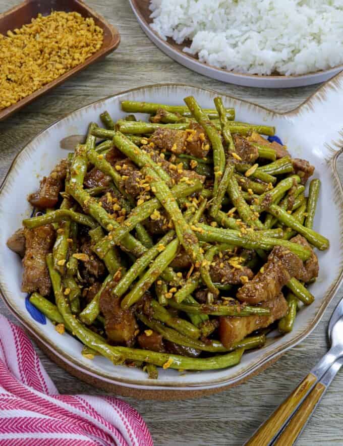 adobong sitaw with pork in a white serving bowl.