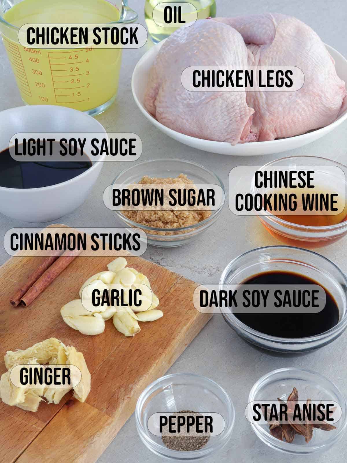 chicken, garlic, onion, brown sugar, dark soy sauce, light soy sauce, Chinese cooking wine, chicken stock, star anise, cinnamon sticks in bowls.
