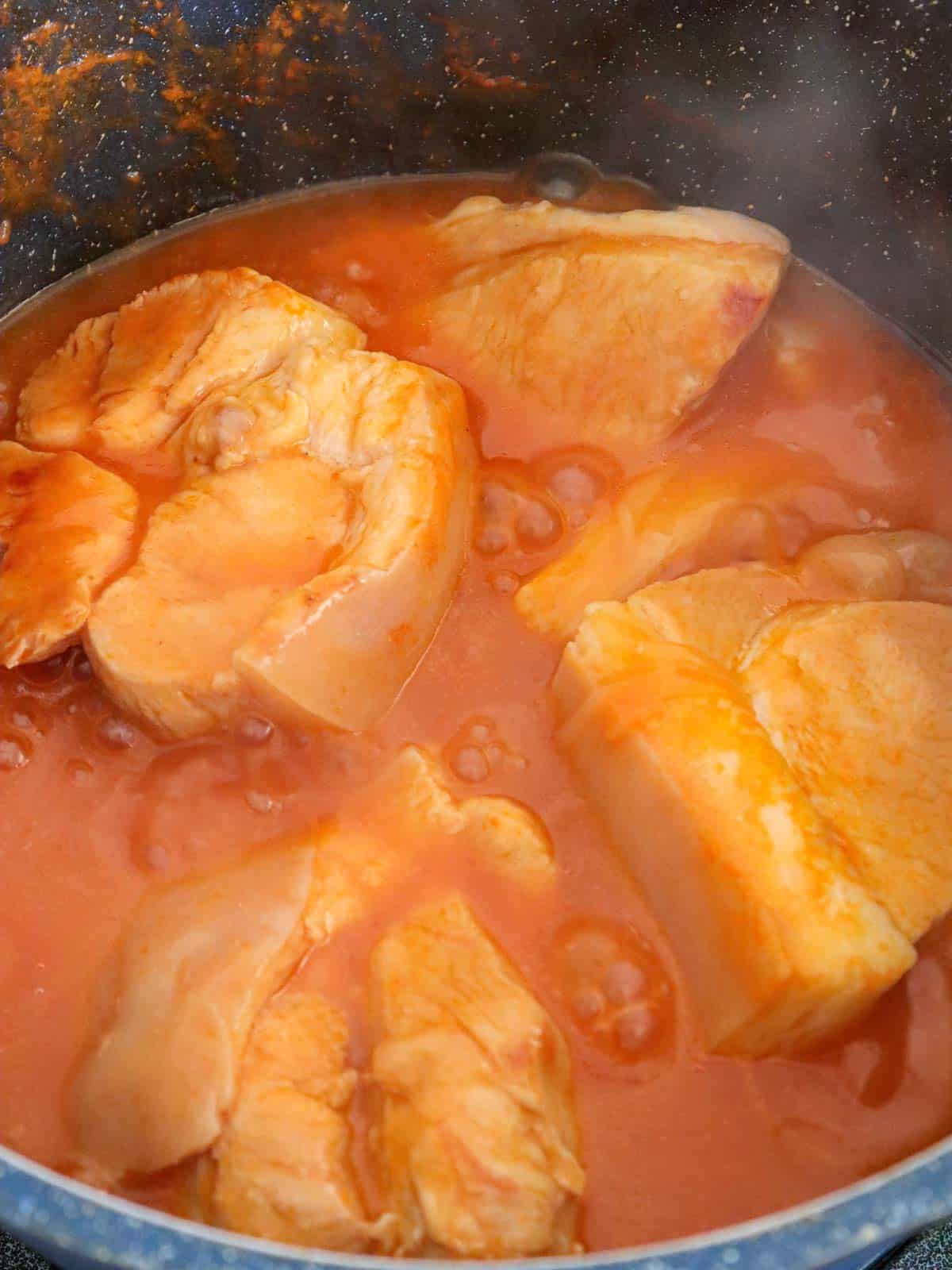 cooking pork with seasonings in a pot.