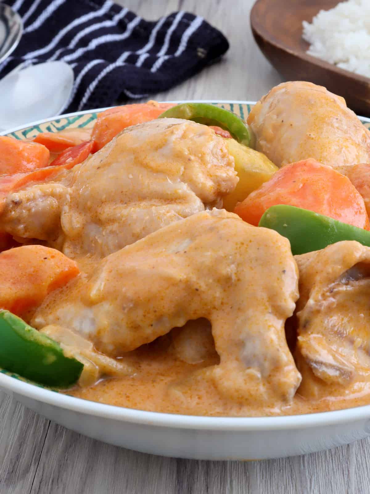 chicken afritada with Nestle all-purpose cream in a serving bowl.