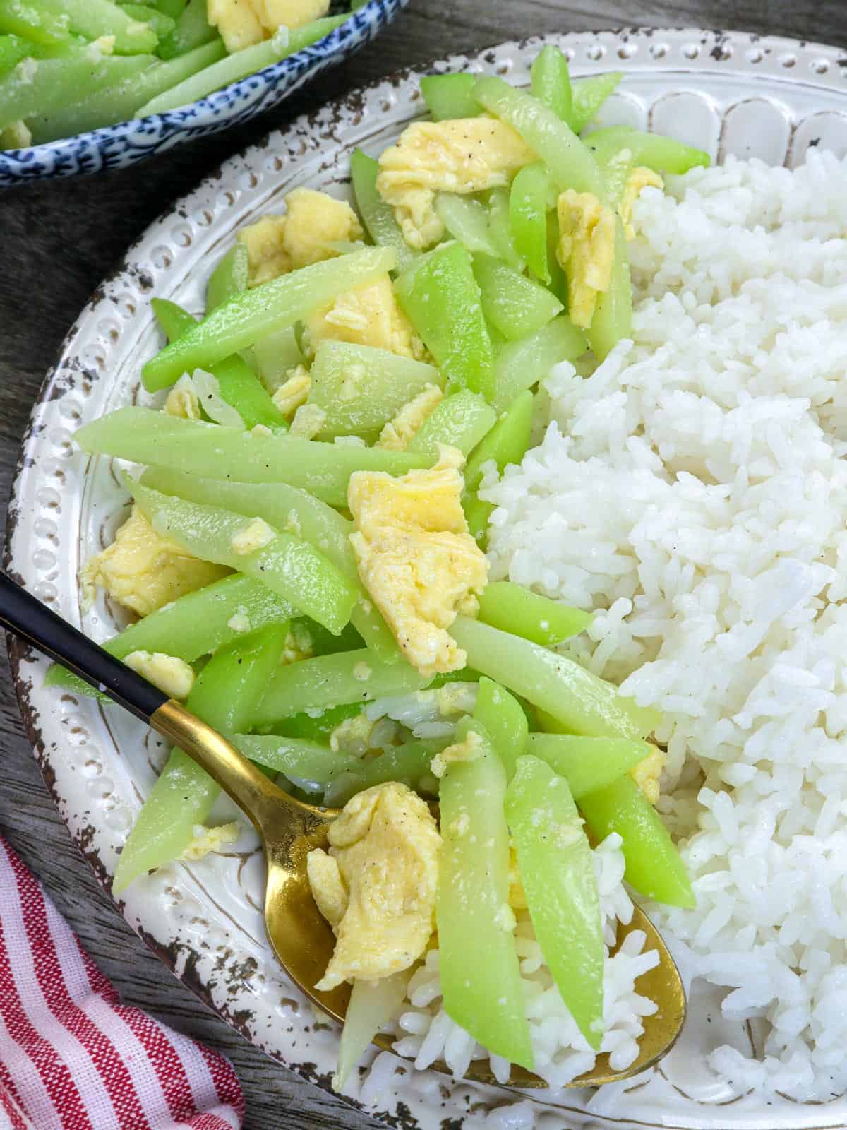 ginisang sayote with eggs on a plate with steamed rice.